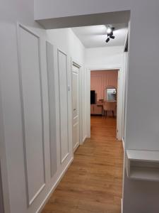 a hallway of a home with white walls and wood floors at Olt view apartament in Călimăneşti