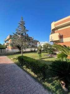 a tree in a park next to a building at The Mazzitellis Home in Nettuno
