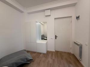 Ch'k'valeriにあるSofis Apartmentのベッドと鏡のある白い寝室 +5枚の写真