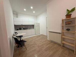 Ch'k'valeriにあるSofis Apartmentの白いキャビネットとテーブルと椅子のあるキッチン