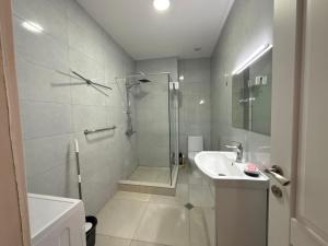 Ch'k'valeriにあるSofis Apartmentのシャワーと洗面台を備えた白いバスルーム