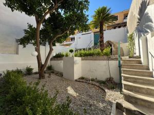 a house with a retaining wall and a tree and stairs at Artop in Messina