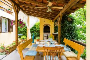 a wooden table and chairs on a patio at Family friendly house with a swimming pool Vojnic Sinjski, Zagora - 17375 in Trilj