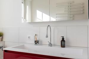 une cuisine blanche avec un évier et une fenêtre dans l'établissement Ferienwohnung Ostseerauschen 2, à Scharbeutz 21 autres photos