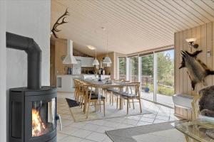 uma cozinha e sala de jantar com lareira numa casa em JB827-Fjerritslev-Revlingestien-93 em Torup Strand