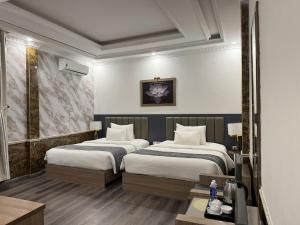 a hotel room with two beds and a table at Sen plaza Hotel in Yên Thành