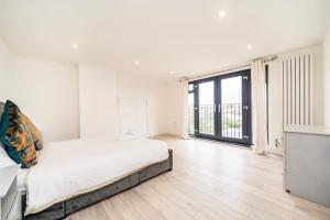 Un dormitorio blanco con una cama y una ventana grande. en Juliet balcony room, en Lower Sydenham Station