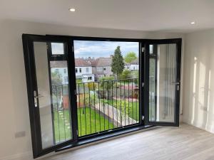 Habitación con puertas correderas de cristal y balcón. en Juliet balcony room, en Lower Sydenham Station