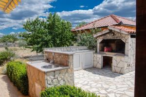 eine Außenküche mit einer Spüle und einem Backofen in der Unterkunft Family friendly house with a swimming pool Gornje Planjane, Zagora - 19733 in Unešić