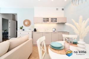 a white living room with a white couch and a table at Apartament na klifie - Łukęcin in Łukęcin