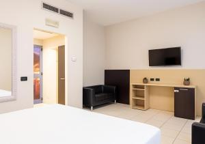 ミラノにあるSechi Hotel Milanoのベッドと机、テレビが備わったホテルの部屋