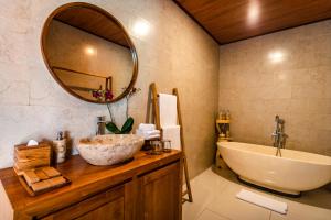 a bathroom with a sink and a large mirror at Ellena Resort Tegallalang by Dhananjaya Hospitality in Tampaksiring
