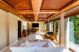 Una sala de estar con un sofá y un televisor en Ellena Resort Tegallalang by Dhananjaya Hospitality, en Tampaksiring