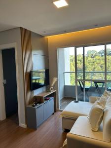 a room with two beds and a television in it at Denny Prime Loft - Executive Apartment in Extrema in Extrema