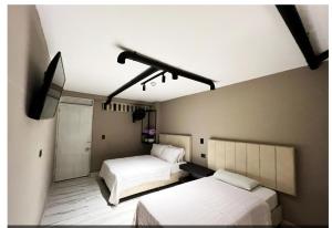 a room with two beds and a television in it at Hotel Natural Medellin in Medellín +17 photos