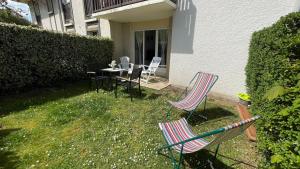 2 Stühle und ein Tisch im Hof eines Hauses in der Unterkunft Studio avec jardin centre ville Cabourg La Roseraie in Cabourg