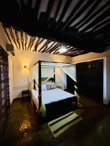 a bedroom with a canopy bed in a room at Villa Kazungu in Ukunda +6 photos