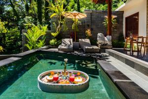 Una piscina con un tazón de comida en el medio en Ellena Resort Tegallalang by Dhananjaya Hospitality, en Tampaksiring