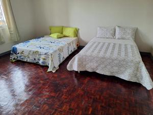 a bedroom with two beds and a wooden floor at Luca hostel in San José