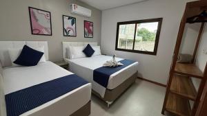 Un dormitorio con dos camas y una ventana en Refúgio de Luxo 11 Hospedes 500m Praia de Pitinga, en Porto Seguro