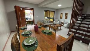 Un comedor con una mesa y una sala de estar. en Refúgio de Luxo 11 Hospedes 500m Praia de Pitinga, en Porto Seguro