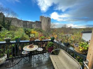 a balcony with a table and chairs and a castle at Chateau Terrace Georgian House in Chepstow