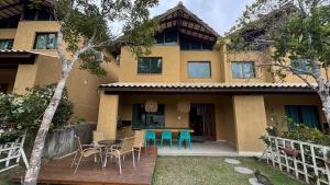 una casa con sillas y una mesa frente a ella en Refúgio de Luxo 11 Hospedes 500m Praia de Pitinga, en Porto Seguro