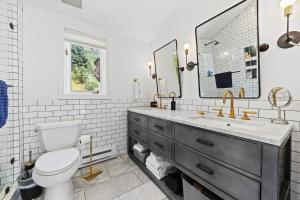 a bathroom with a toilet and a sink and a mirror at Modern Alpine Retreat at Vail in Vail +17 photos