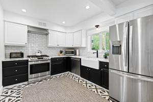 a kitchen with black cabinets and a stainless steel refrigerator at Modern Alpine Retreat at Vail in Vail
