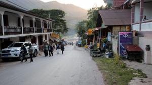 een groep mensen die door een straat lopen in een stad bij DP Guest-house in Pakbeng
