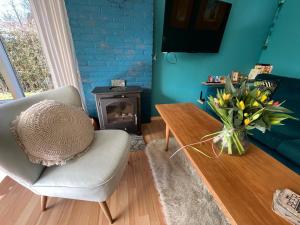 un soggiorno con sedia, tavolo e camino di Vakantiebungalow Vrijzicht a Kortgene