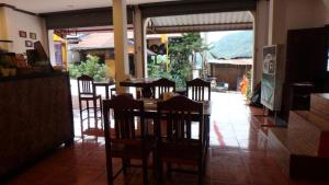 een eetkamer met een tafel en stoelen in een restaurant bij DP Guest-house in Pakbeng