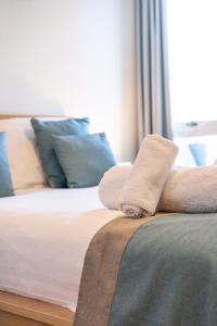 Un primer plano de una cama con toallas. en Sleek Apartment with Balcony - City Centre - Free Parking, Fast WiFi and 55'' Smart TV by Yoko Property, en Milton Keynes