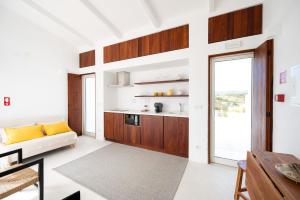 a living room with a couch and a kitchen at Monte de Torquines - Casa de Campo com piscina em Odemira in Odemira