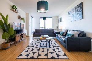 una sala de estar con un sofá y una mesa en Sleek Apartment with Balcony - City Centre - Free Parking, Fast WiFi and 55'' Smart TV by Yoko Property, en Milton Keynes