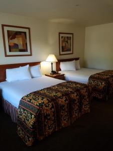 duas camas num quarto de hotel ao lado um do outro em Premier Inns Tolleson em Phoenix