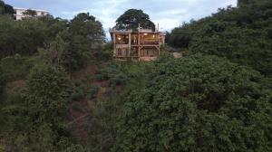 a house sitting on top of a hill with trees at Casba Hostel in Las Terrenas