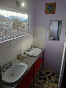 ein Badezimmer mit zwei Waschbecken und einem Fenster in der Unterkunft El Kamaruco Hostel in El Chalten