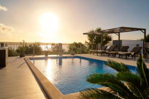 ein Swimmingpool mit Stühlen und einem Pavillon in der Unterkunft Stunning seaview Villa Katharina in Šarić