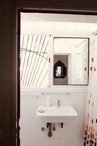a white bathroom with a sink and a mirror at Olas Surf Camp in Imsouane +94 photos