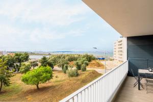 ein Balkon mit Blick auf eine Straße und Bäume in der Unterkunft Lisbon South Bay - Orizon Seixal in Seixal
