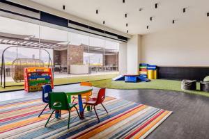 a room with a table and chairs and a playground at Moderno Depa a 3 mins de Fundidora y Tec de Mty in Monterrey