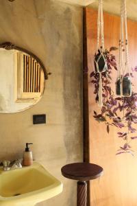 a bathroom with a yellow sink and a stool at Casba Hostel in Las Terrenas