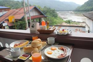 een ontbijttafel met ontbijtproducten op een balkon bij DP Guest-house in Pakbeng