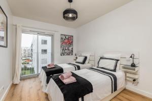 zwei Betten in einem Zimmer mit Fenster in der Unterkunft Lisbon South Bay - Orizon Seixal in Seixal