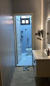 Un baño con una puerta que conduce a un inodoro y un lavabo. en Afandina Hotel, en Kuwait