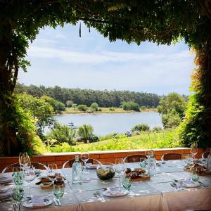 a table with wine glasses and a view of a lake at Secret Spot Apartment - Quinta da Barca in Esposende
