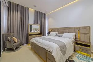 Un dormitorio con una cama grande y una silla. en Yomsdale Air B N B, en Lekki