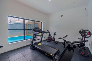un gimnasio con 3 bicicletas estáticas y una ventana en Yomsdale Air B N B, en Lekki