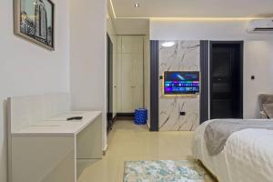 Un dormitorio con una cama, un escritorio y un televisor. en Yomsdale Air B N B, en Lekki 3 fotos más